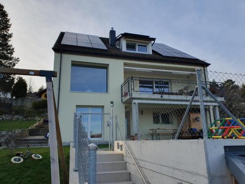une maison avec des panneaux solaires en haut dans l'établissement Magnifique Studio à louer, à Evilard