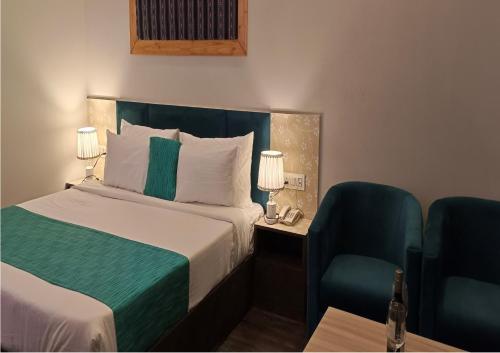 a hotel room with a bed and a chair at Hotel Square One by D'Polo Dharamshala in Dharamshala