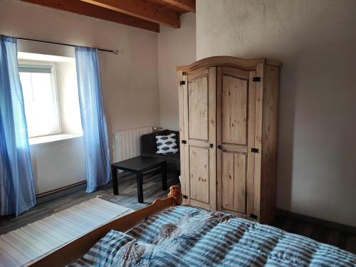 a bedroom with a bed and a cabinet and a chair at Apartment Le 1739 in La Coste