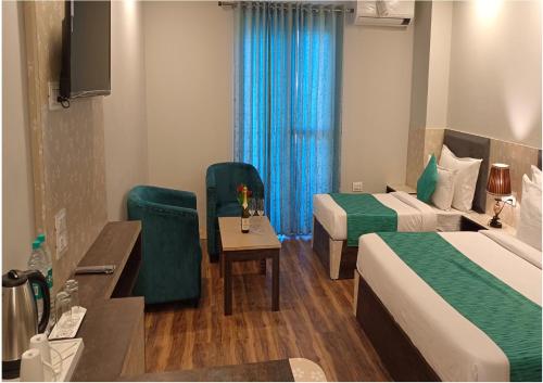 a hotel room with two beds and a table and chairs at Hotel Square One by D'Polo Dharamshala in Dharamshala