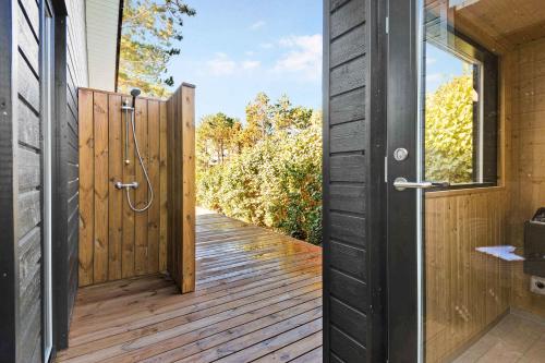 an open door to a deck with a wooden fence at New Summer House From 2021 With Sea View in Millinge