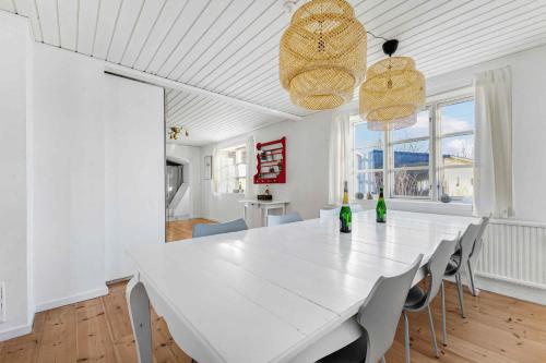 HasleにあるLovely Spacious Holiday Home On Bornholmの白いテーブルと椅子のある白いダイニングルーム