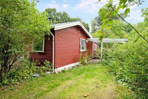 a red house with a dirt road in front of it at Lovely Holiday Home Near The Beach in Vordingborg