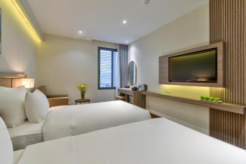 a hotel room with a bed and a flat screen tv at Maris Hotel Nha Trang in Nha Trang