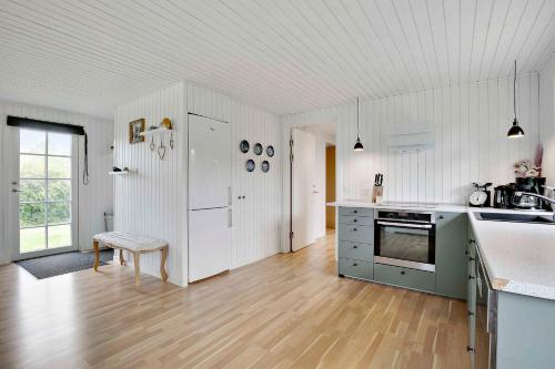 a kitchen with white cabinets and a counter top at Lovely Cottage For Family And Friends in Kirke-Hyllinge