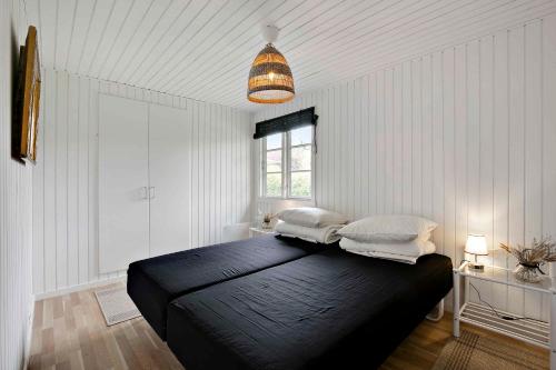 a bedroom with a black bed with two pillows on it at Lovely Cottage For Family With Children And Friends in Kirke-Hyllinge