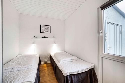 Dos camas en una habitación con ventana. en Holiday Home In The First Row To The North Sea, en Vestervig