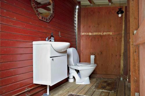 a red bathroom with a toilet and a sink at Charming House With Big Private Terrace in Allinge