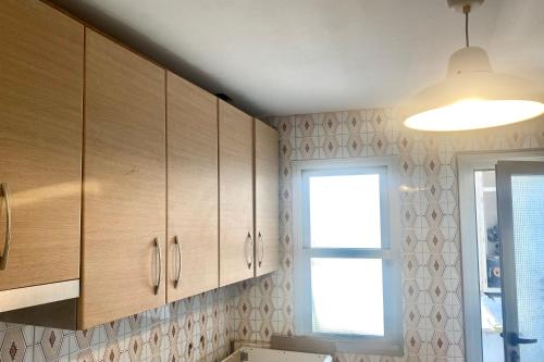 una cocina con armarios de madera y una ventana en Guest house Croqueta Espinardo en Espinardo