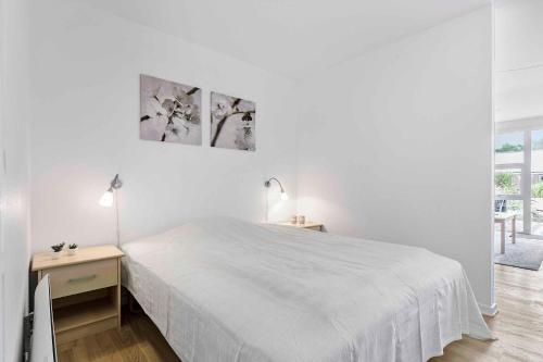una camera bianca con un letto bianco e un tavolo di Holiday Apartment Close To Dueodde Beach a Neksø