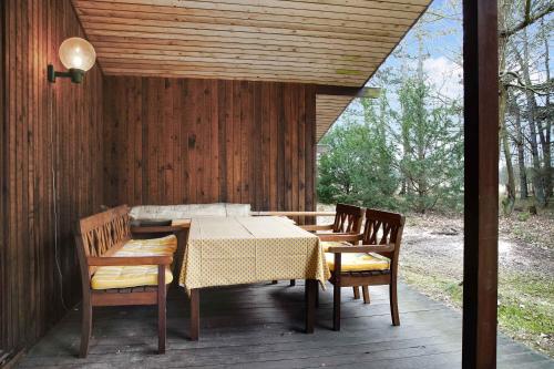 a table and chairs on a wooden deck with a table and chairs at Nice Summer House In The Middle Of The Forest in Store Fuglede