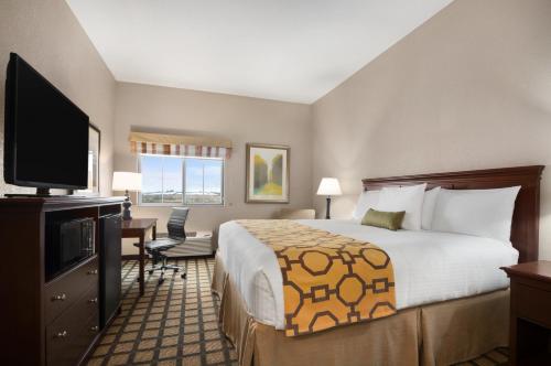 a hotel room with a bed and a flat screen tv at Baymont Inn & Suites by Wyndham Odessa in Odessa