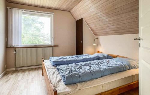a large bed in a room with a window at Balkalyngen in Neksø