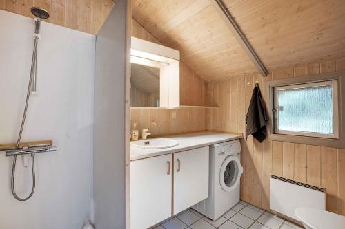 een badkamer met een wastafel en een wasmachine bij Welcome To Our Lovely Holiday Home in Gilleleje