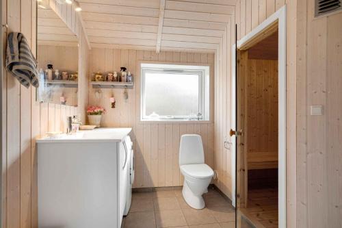 uma casa de banho com um WC, um lavatório e uma janela em Newer Holiday Home In Green Surroundings em Jægerspris