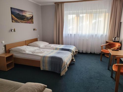 um quarto de hotel com duas camas e uma janela em Hotel *** NAT Wisła em Wisla