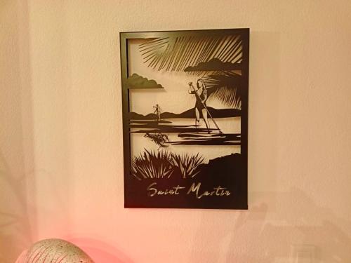 a picture of a man on a surfboard hanging on a wall at PERLE DES ANTILLES in Oyster Pond