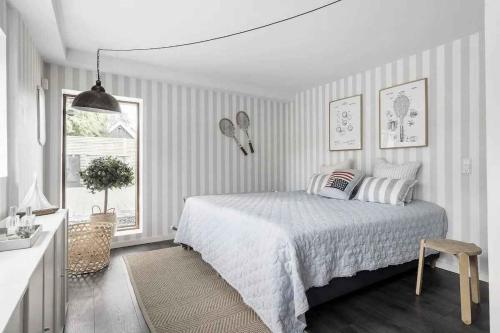 een witte slaapkamer met een bed en een raam bij Luxurious Holiday Home In Tisvildeleje in Tisvildeleje