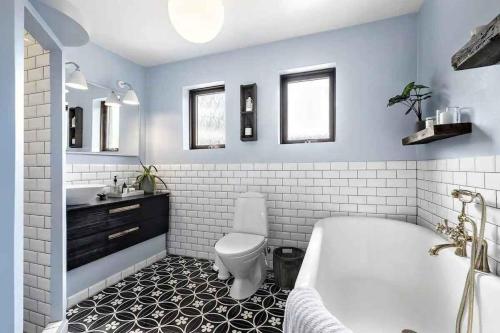 een badkamer met een bad, een toilet en een wastafel bij Luxurious Holiday Home In Tisvildeleje in Tisvildeleje