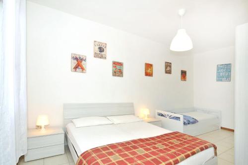 um quarto branco com uma cama e duas mesas de cabeceira em Casette Baradel - Agenzia Caorle em Caorle