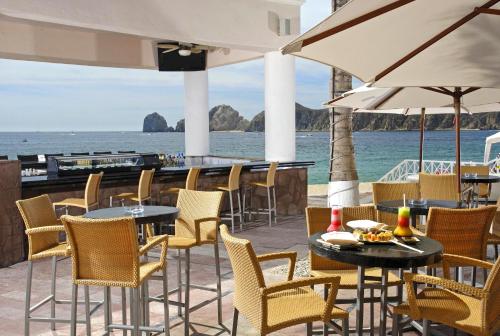 a patio with tables and chairs and the ocean at Pueblo Bonito Rose Resort & Spa - All Inclusive in Cabo San Lucas