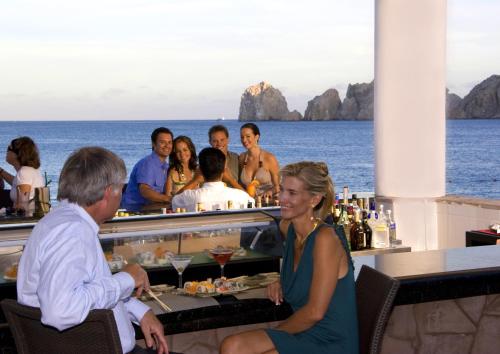 a man and woman sitting at a table with food at Pueblo Bonito Rose Resort & Spa - All Inclusive in Cabo San Lucas