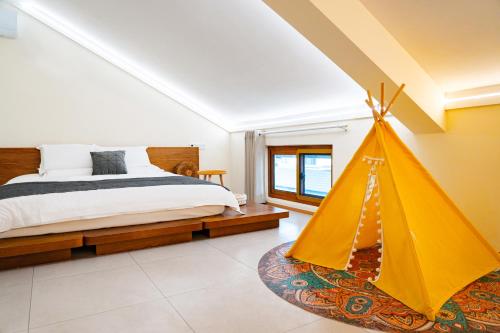 una camera con letto e tenda gialla di Yi Chen San She a Hangzhou