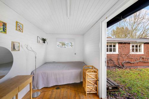 1 dormitorio con 1 cama en una habitación blanca en Cozy Holiday Home Close To Forest And Beach en Hasle