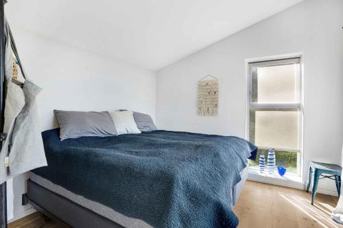 ein weißes Schlafzimmer mit einem Bett und einem Fenster in der Unterkunft Modern, Spacious House With Ocean View Close To The Beach in Vejby