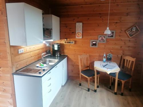 a kitchen with a sink and a table with chairs at Ferienwohnung“puutalossa“ in Sehlen