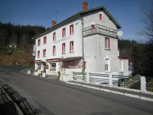 a large white building on the side of a road at Hotel gites des touristes in Vollore-Montagne