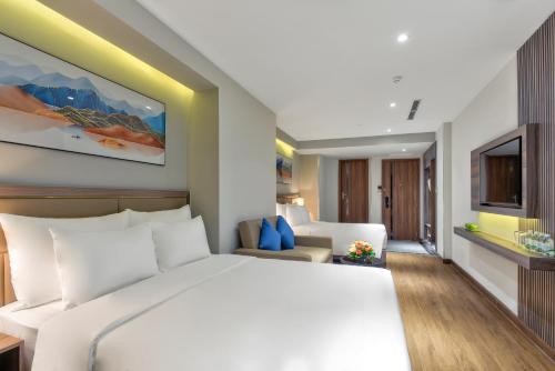 a bedroom with a large bed and a living room at Maris Hotel Nha Trang in Nha Trang