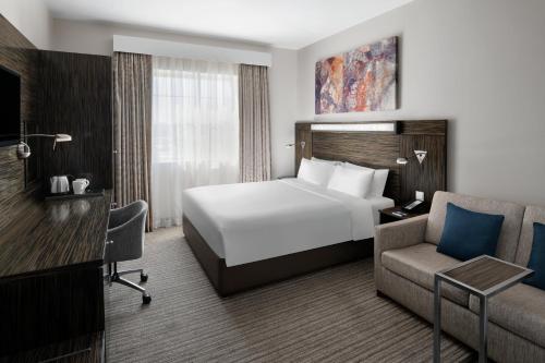 a hotel room with a white bed and a chair at Holiday Inn Express Dubai, Jumeirah, an IHG Hotel in Dubai