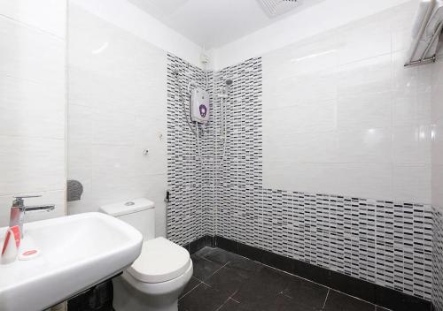 Hotel 75 Temerloh في تيميرلوه: حمام ابيض مع مرحاض ومغسلة
