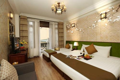 a hotel room with two beds and a chandelier at Golden Lotus Hotel & Spa in Hanoi