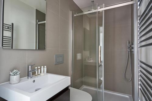 a bathroom with a white sink and a shower at Hammersmith Mews by Viridian Apartments in London