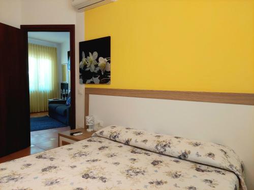 a bedroom with a bed and a yellow wall at Villa Margot in Agropoli