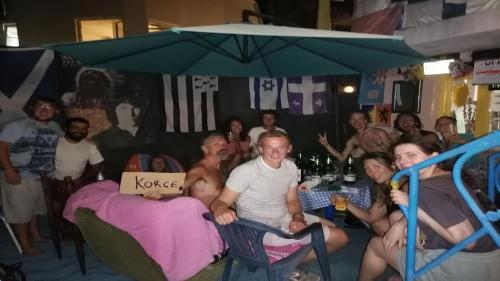 a group of people sitting in chairs under an umbrella at Blue Lake hostel in Ohrid