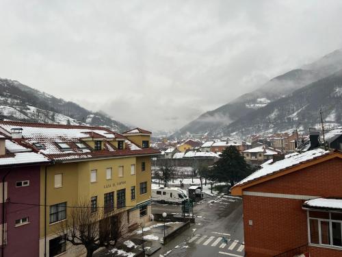 una ciudad con nieve en los tejados de edificios en Apartamentos Turísticos Cuirgu, en Felechosa