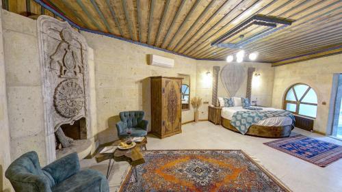 een slaapkamer met een bed en stoelen in een kamer bij Premium Cappadocia House in Goreme