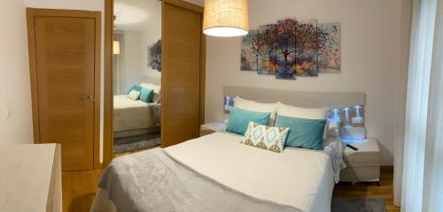 1 dormitorio con cama blanca y almohadas azules en VIANA, en Monforte de Lemos