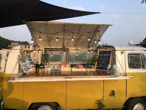 a yellow food truck with awning on top of it at The Factory Ba Vì in Ba Vì
