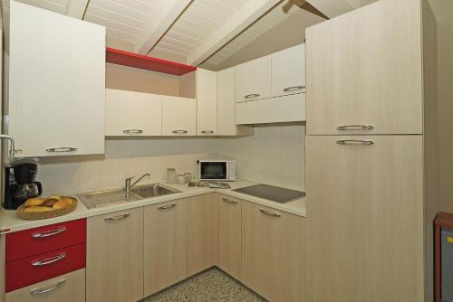 a small kitchen with white cabinets and a sink at Onda Blu Resort in Manerba del Garda
