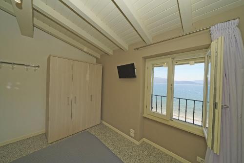 a room with a large window and a television at Onda Blu Resort in Manerba del Garda