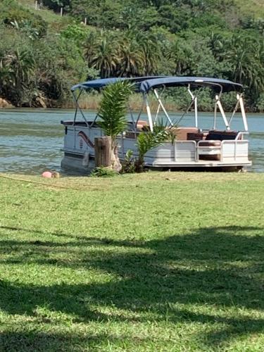 a boat on the water with a palm tree on it at Umtamvuna River Lodge in Port Edward