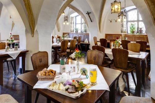 a restaurant with tables and chairs with a tray of food at Hotel Pfaubräu in Trostberg an der Alz