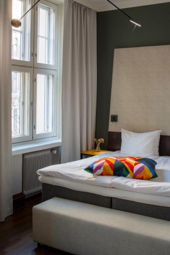 a bedroom with a large bed and two windows at Hotel Klaus K in Helsinki