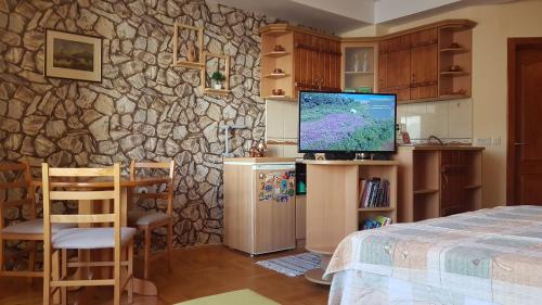 ein Schlafzimmer mit einem TV und einer Steinmauer in der Unterkunft Luccia Apartments - Ohrid City Centre in Ohrid