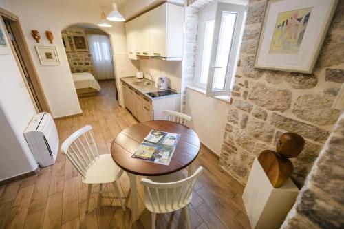 a kitchen and dining room with a table and chairs at Apartmani Art Karampana in Kotor
