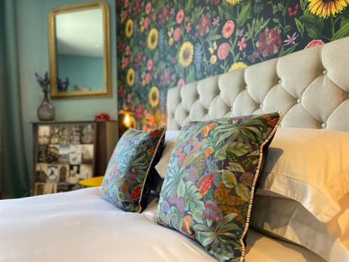 une chambre avec un lit avec deux oreillers et un miroir dans l'établissement Maison Belmont Eymet, à Eymet